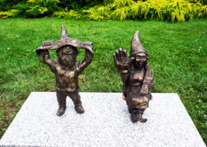 2 Krasnale, chłopak i dziewczyna przymocowane go granitowej płyty