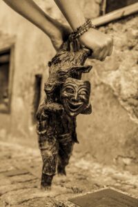 Na obrazku widać figurkę koziołka rzeźbę z brązu, idzie dynamicznie i trzyma przed sobą maskę teatralną.