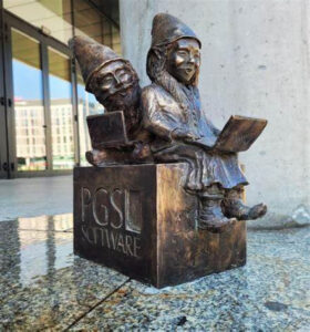 Ada i Fakapek, krasnale siedzące z laptopami na kolanach przed firmą Software.