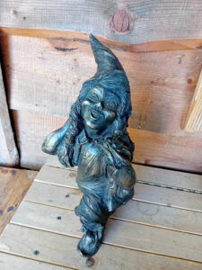 Krasnalka Uczennica – rzeźba przedstawiająca dziewczynkę kroczącą do szkoły, z plecakiem, workiem na buty i kanapką w dłoni.